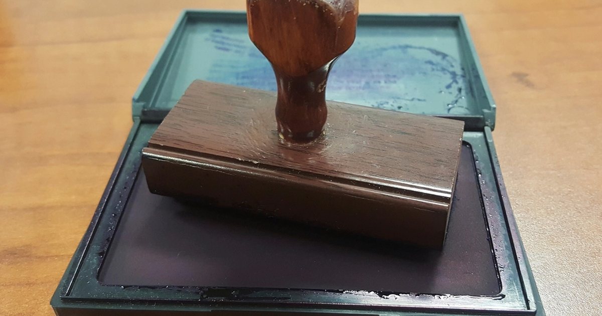 Rubber stamp with an ink pad on a wooden table