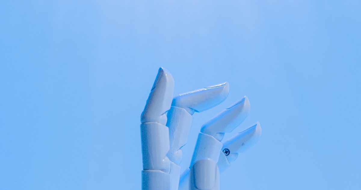 Mano robótica extendida hacia arriba sobre un fondo azul, simbolizando un asistente virtual