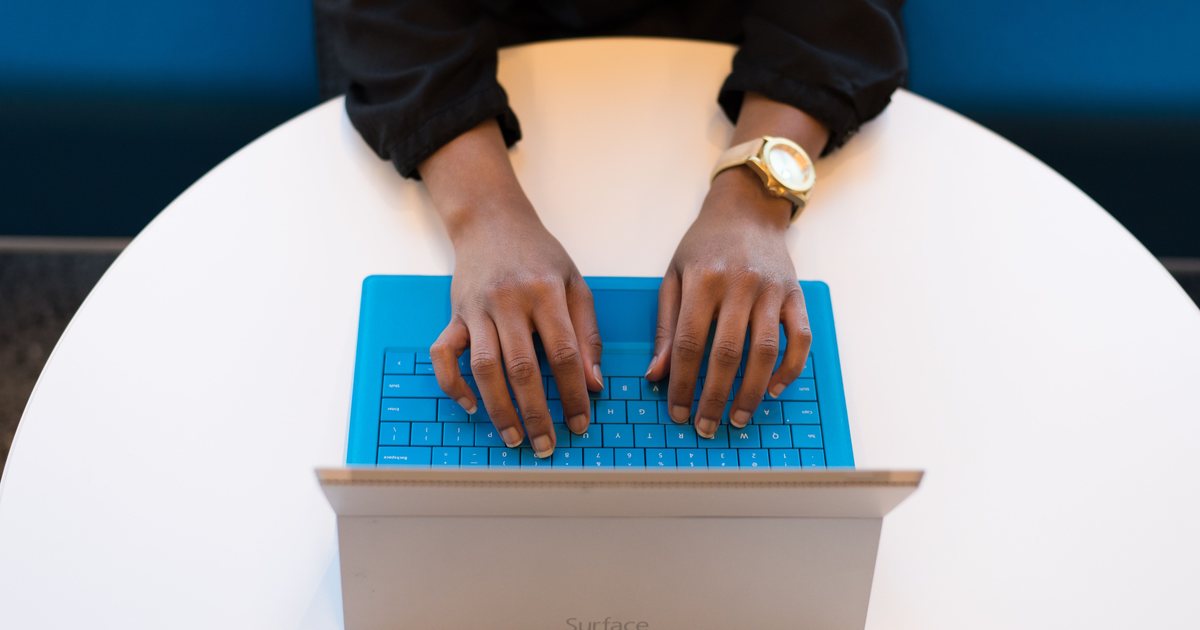 Manos escribiendo en el teclado de un portátil, vistas desde arriba