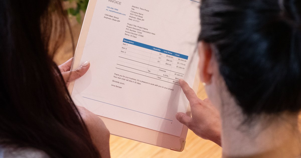 Dos personas revisando juntas un documento impreso