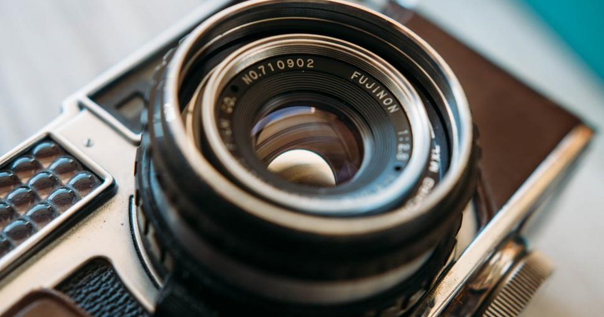 Primer plano de un objetivo de cámara fotográfica en tonos oscuros