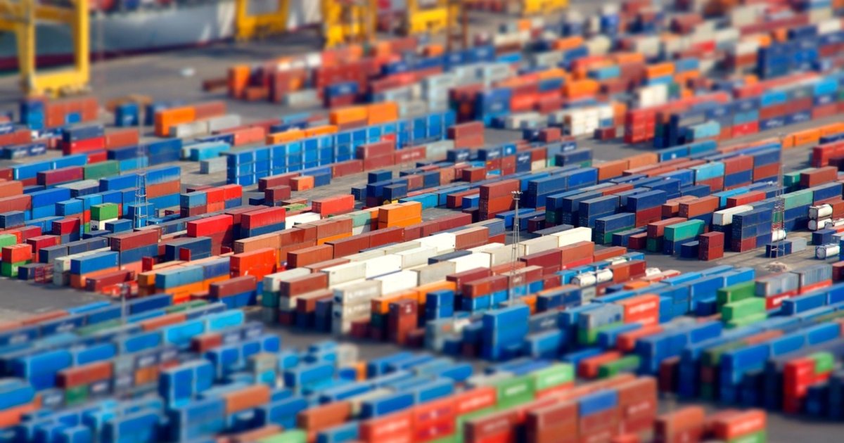 Contenedores de transporte apilados de varios colores en un puerto