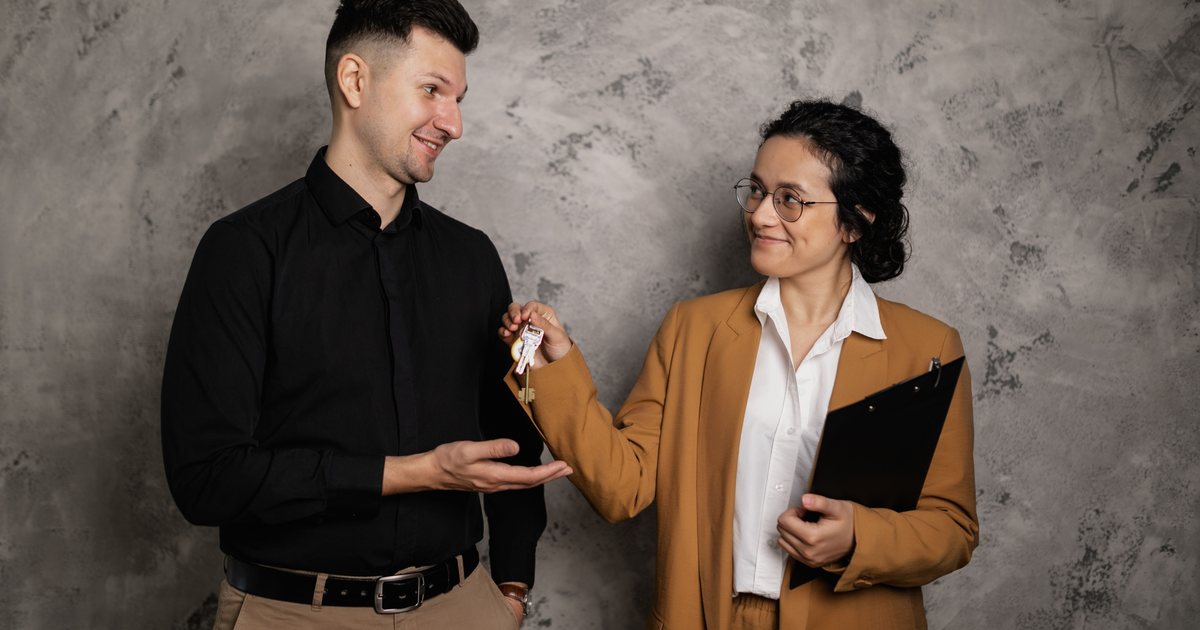Dos personas intercambiando las llaves de una vivienda