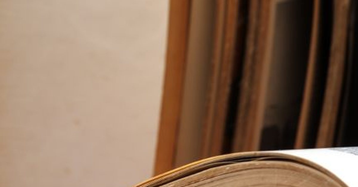 Libro grueso y antiguo abierto sobre un atril de madera, con luz cálida