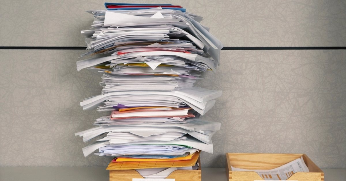 Pila de documentos y carpetas apiladas sobre un escritorio de oficina