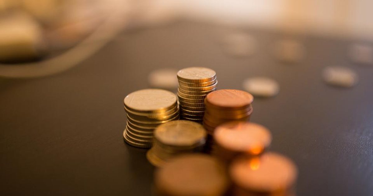 Pilas de monedas con luz cálida desenfocada de fondo
