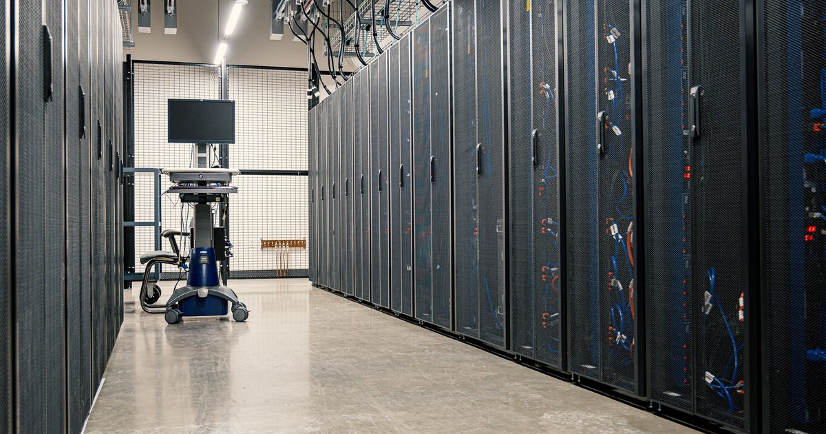 Pasillo de un centro de datos con racks de servidores y cableado de red