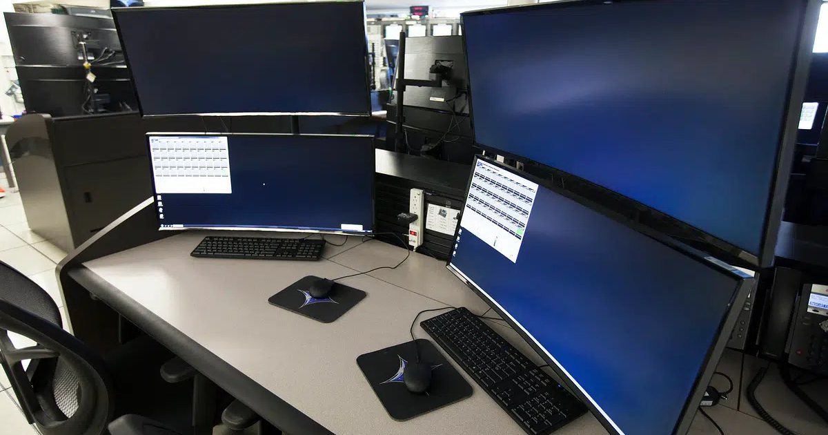 Puesto de trabajo con varios monitores curvos en tono azul en una sala técnica