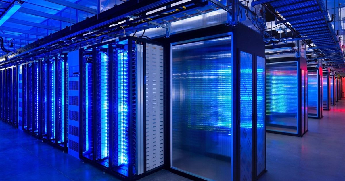 Pasillo de una sala de servidores iluminada en azul con racks a ambos lados