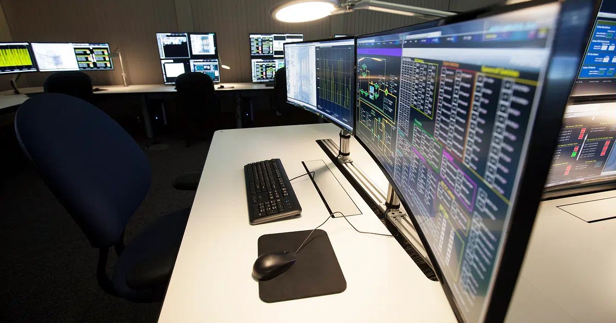 Sala de control con varios monitores mostrando paneles de datos técnicos