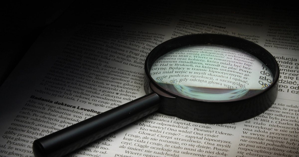 Lupa de aumento sobre un texto impreso, en primer plano